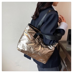 Detail view of metallic quilted tote bag with wide black strap and large capacity