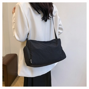 Détail de la bandoulière noire en nylon avec ruban mode et poche latérale zippée