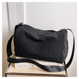Détail du sac cabas en nylon noir avec bandoulière réglable et surface plissée