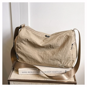 Détail d'un sac fourre-tout en nylon kaki avec fermeture éclair et logo sur support