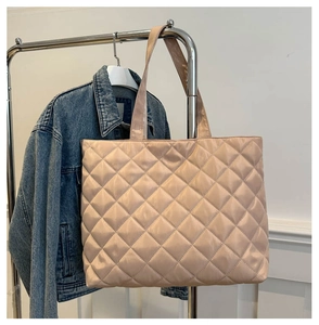 Detail of champagne quilted tote bag with large capacity and soft sheen fabric texture