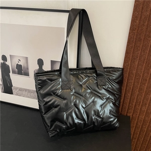 Minimalist black quilted tote bag with glossy finish and wide shoulder strap for women