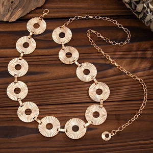 Macro view of gold punk metal body chain with hollow circular disks and rustic wood background