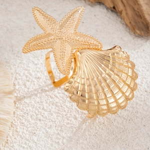Detailed close-up of golden starfish and seashell pendants on a textured beach background
