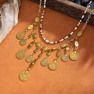 Détail de collier bohème multicouche avec pendentifs pièces vintage et perles colorées sur fond rustique