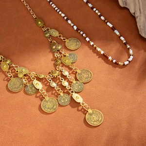 Ensemble de colliers bohèmes avec pièces dorées et perles ethniques sur fond texturé