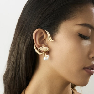Détail d'un ear cuff sirène doré orné d'un pendentif en perle baroque pour femmes