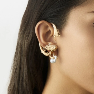 Détail d'un ear cuff sirène dorée avec perle baroque blanche sur un mannequin