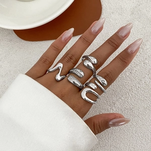 Detail view of five silver-toned irregular liquid metal rings with sparkling zircon accents