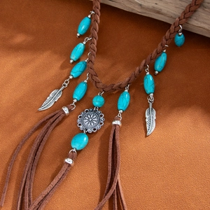 Detail of bohemian turquoise fringe necklace with silver feather charms on suede cord
