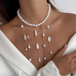 Détail d'un choker en perles avec franges dorées et perles baroques sur un mannequin