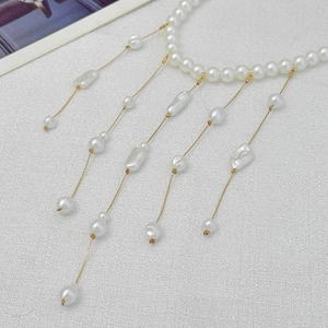 Détail du collier à pampilles en perles baroques avec chaînes dorées et pendentifs