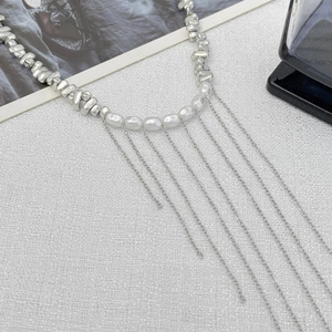 Détail du collier à glands argentés avec des perles et des fausses perles blanches