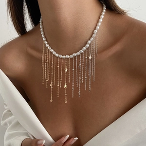 Détail du collier à pampilles en perles baroques avec chaînes métalliques et étoiles