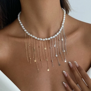Détail du collier de perles avec pampilles métalliques et breloques étoiles sur le cou