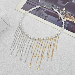 Détail du collier de perles avec franges métalliques bicolores et breloques en étoile