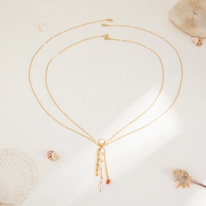 Detail of bohemian gold layered body chain with pearls and natural stone charms