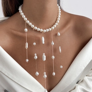 Collier à pampilles en perles baroques et chaînes dorées sur revers en satin