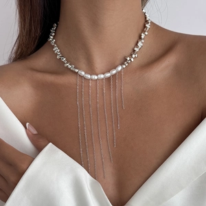 Collier élégant avec perles et glands argentés porté sur le cou d'un modèle