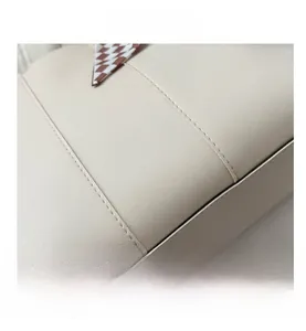 Detail view of beige leather texture with neat stitching and checkered silk scarf