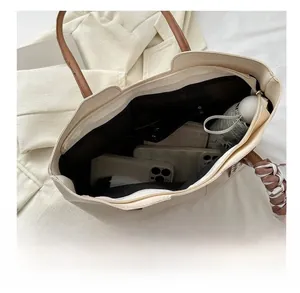 Interior view of large beige tote bag showing phone, umbrella and zipper pocket capacity