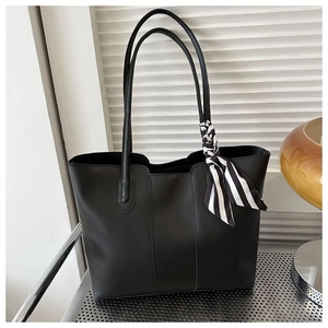 Minimalist black tote bag with striped scarf detail on white minimalist background