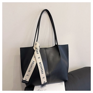 Détail du sac cabas en cuir noir avec ruban blanc élégant et coutures contrastées