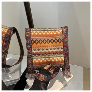 Détail d'un sac bandoulière ethnique avec motifs tissés colorés et franges argentées