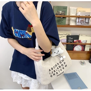 Chic white canvas tote bag with shoulder strap and cloud pendant shown in a room