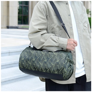 Detail view of a camouflage travel tote bag with side drawstring pocket and black straps