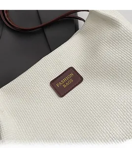 Dettaglio della borsa tote intrecciata bianca con tracolla in pelle marrone