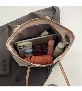 Interior view of large beige tote bag showing storage for laptop and daily essentials