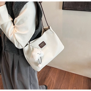 Dettaglio della borsa tote in velluto a coste bianco con tracolla in pelle marrone