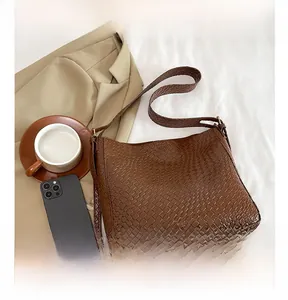 Detailed view of dark brown woven texture hobo shoulder bag with a wide strap