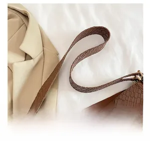 Detail of brown crocodile pattern shoulder strap with premium gold metal buckle