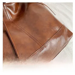 Detail of retro glossy brown leather with exquisite double stitching on a shoulder bag