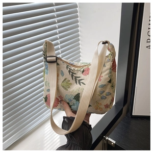 Détail de broderie florale sur sac en toile beige avec bandoulière ajustable