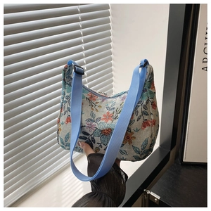 Détail du tissu jacquard floral rétro et de la bandoulière en nylon bleu du sac à main