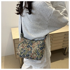 Détail du sac d'épaule en toile florale montrant l'imprimé coloré et la bandoulière