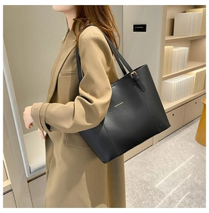 Detail der schwarzen Leder-Tote-Bag mit goldener Aufschrift und verstellbarer Metallschnalle