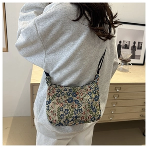Détail du sac jacquard floral avec motif de fleurs bleues et bandoulière noire fine