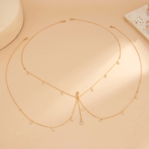 Close-up of gold layered body chain with starfish shell pendants and sparkling rhinestones