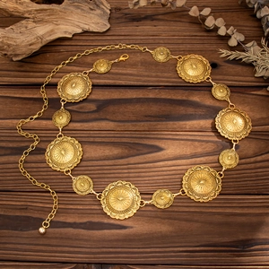 Detailed macro view of vintage sun-embossed golden discs on a bohemian metal waist chain