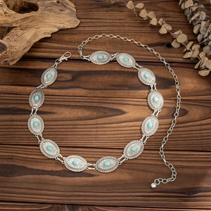 Detail of bohemian silver waist chain with oval turquoise stones on a vintage wood background