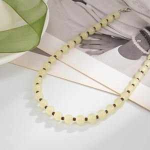 Détail d'un collier de perles vintage avec perles jaunes et ruban vert élégant