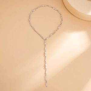 Dettaglio di una collana a Y d'argento con maglie metalliche dalla trama stropicciata