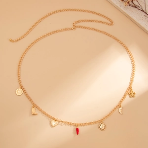 Dettaglio cintura a catena dorata con ciondoli a forma di sole, stivale, cuore e peperoncino