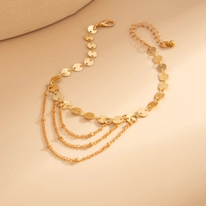 Layered gold sequin anklet with snake chains and bow pendant for beach styling