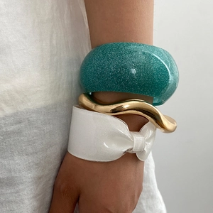 Set di tre bracciali geometrici con resina glitterata e cerchi dorati ondulati in metallo
