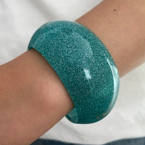 Dettaglio macro del bracciale largo in resina turchese con particelle di glitter argento